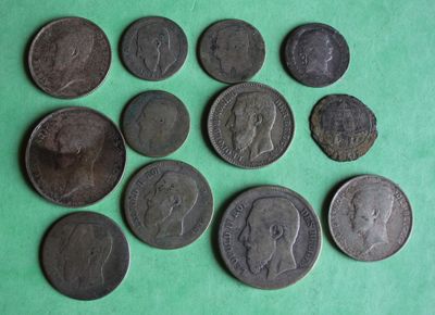 several different types of coins are arranged on a green surface
