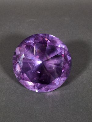 a close up of a purple gemstone on a black surface