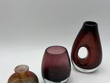 three vases sitting next to each other on a white surface