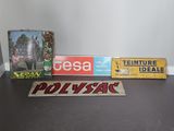 Plusieurs panneaux sont posés sur une table devant un mur blanc.