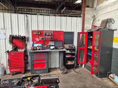 un garage avec beaucoup d'outils et des outils sur le sol