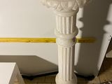 un socle blanc au milieu d'un sol carrelé