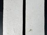 pair of white rectangular stone plaques with metal handles on a black background