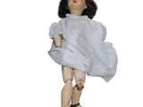 an old doll with a white dress and black shoes on a white background