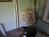 une photo d'un coin de pièce avec une lampe et des tableaux accrochés au mur
