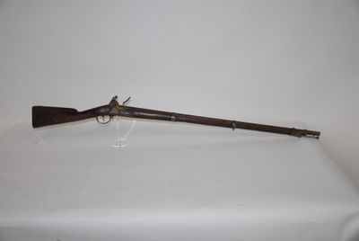 an old rifle with a wooden handle on a white table