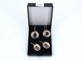 a pair of earrings in a black box on a white background