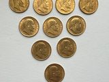 several gold coins are arranged in a triangle on a white surface