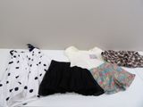 trois robes et un foulard posés sur une table