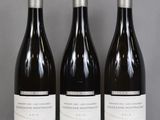 three bottles of wine are lined up on a table