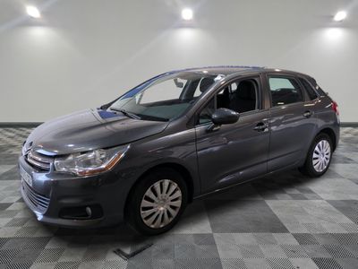 une voiture grise garée dans un garage au sol carrelé