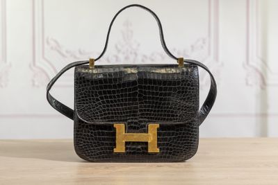 a black handbag with gold hardware on a wooden table