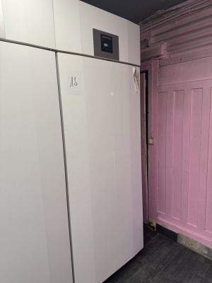 un réfrigérateur blanc et une porte rose dans une pièce
