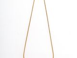 un collier en or avec une longue chaîne sur fond blanc