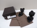 the black sandals are next to a brown scarf and a box