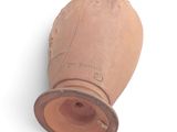 a clay vase that is sitting on a white surface