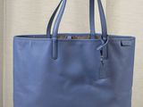 un sac fourre-tout bleu posé sur une table en bois