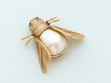 an image of a gold bee broochle with a pearl and diamonds