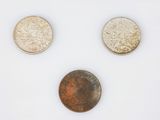 three different coins are shown on a white surface with a white background