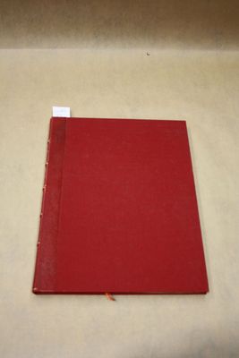 un livre rouge posé sur une surface blanche