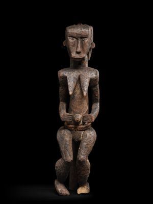 une image représentant une statue en bois d'un homme assis sur une surface noire