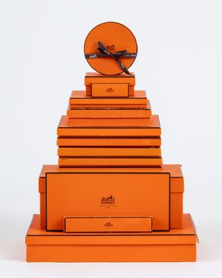 une image représentant une pile de cartons orange surmontée d'une horloge