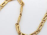 a close up of a gold chain on a white surface