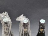 three bottles of wine wrapped in plastic bags sitting on a table