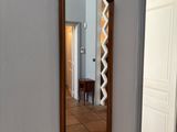 un miroir accroché au mur au-dessus d'un banc dans une pièce