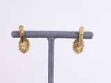 a close up of a pair of earrings on a stand