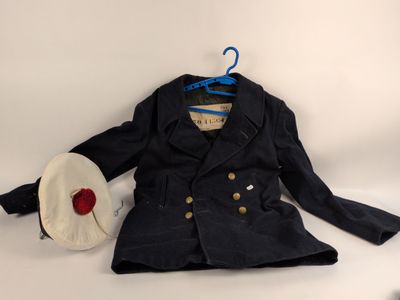 un manteau et un chapeau suspendus à un cintre sur fond blanc