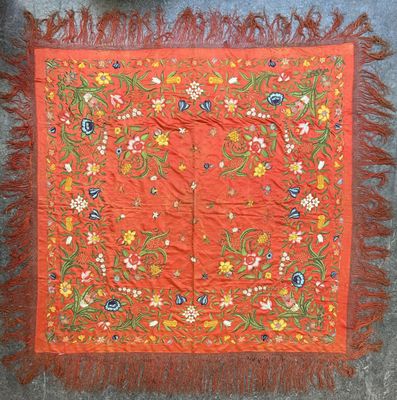 an orange table cloth with flowers and leaves on it