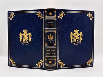un vieux livre bleu aux bords dorés, orné d'un blason sur la couverture