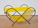 a yellow magazine rack sitting on top of a cement floor