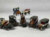 several toy cars are lined up in a row on a white surface