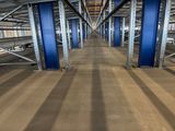a long line of blue poles in the middle of a large warehouse