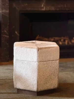 a small white box sitting on the floor in front of a fireplace