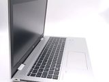 a silver laptop with a black keyboard on a white surface