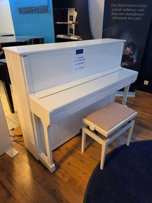 a white piano and a stool in a room
