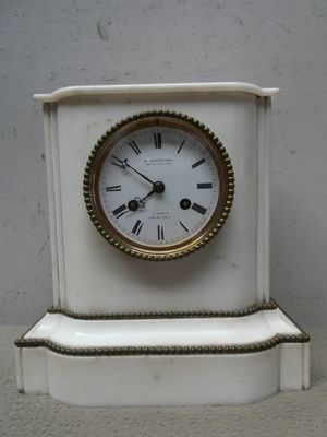 une petite horloge blanche posée sur une table