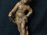 a statue of a boy sitting on top of a wooden base