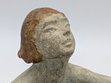 statue of a woman sitting on a rock with her arms crossed