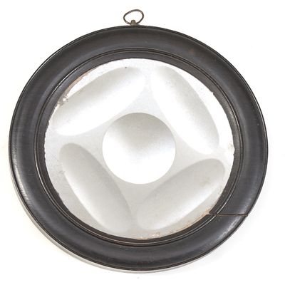 un objet circulaire noir et blanc accroché à un mur