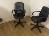 two black office chairs in the corner of a room