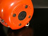 an orange speaker sitting on top of a black table
