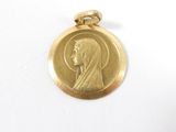 l'image d'une médaille d'or sur laquelle figure le visage d'une femme