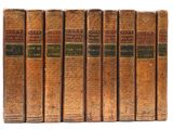 six vieux livres sont alignés sur une surface blanche