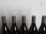 six bottles of wine are lined up in a row on a table