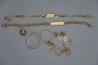 plusieurs bracelets en or, bagues et autres bijoux posés sur une table