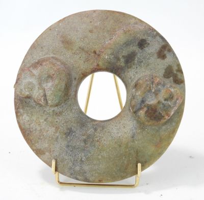 une sculpture en pierre représentant un beignet posée sur un socle